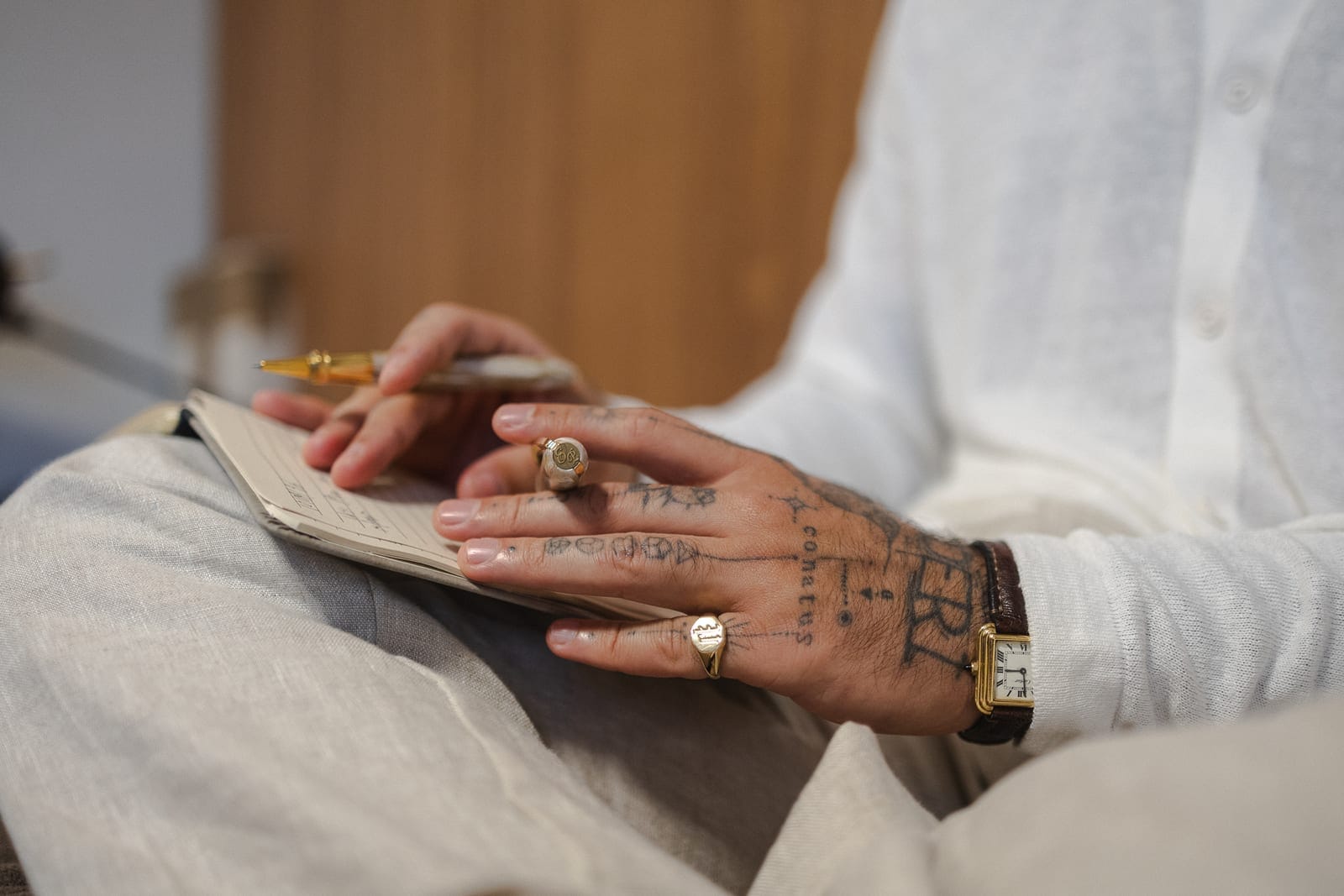 Mãos do Dr. Eric Pascher escrevendo com caneta-tinteiro sobre um caderno